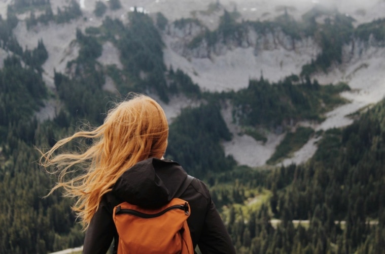 Frau mit roten Haaren blickt auf die Landschaft im Mount Rainier Nationalpark, USA