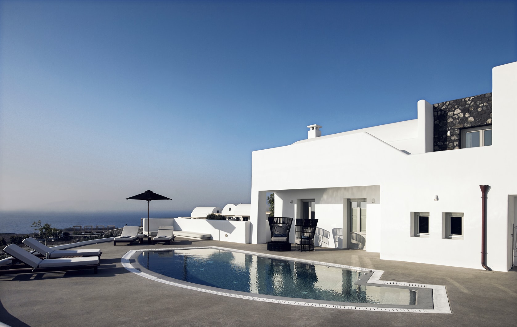 Pool und weiße Villa des Santo Maris Oia Luxury Suites & Spa auf Santorin