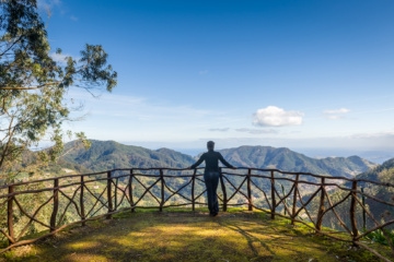 Frau betrachtet die Berglandschaft vom Aussichtspunkt des Parks Santo da Serra. Insel Madeira, Portugal.