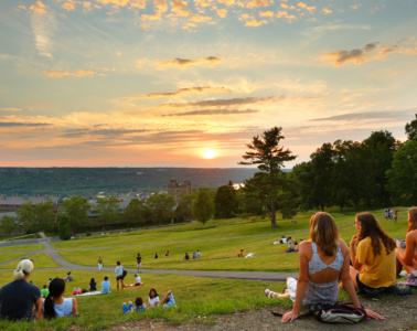 Studenten sitzen in Park in Ithaka und schauen Sonnenuntergang an