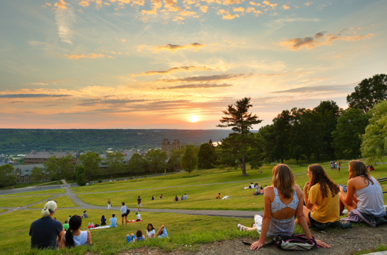 Studenten sitzen in Park in Ithaka und schauen Sonnenuntergang an
