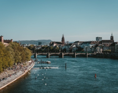Junge Menschen sitzen am Rhein in Basel