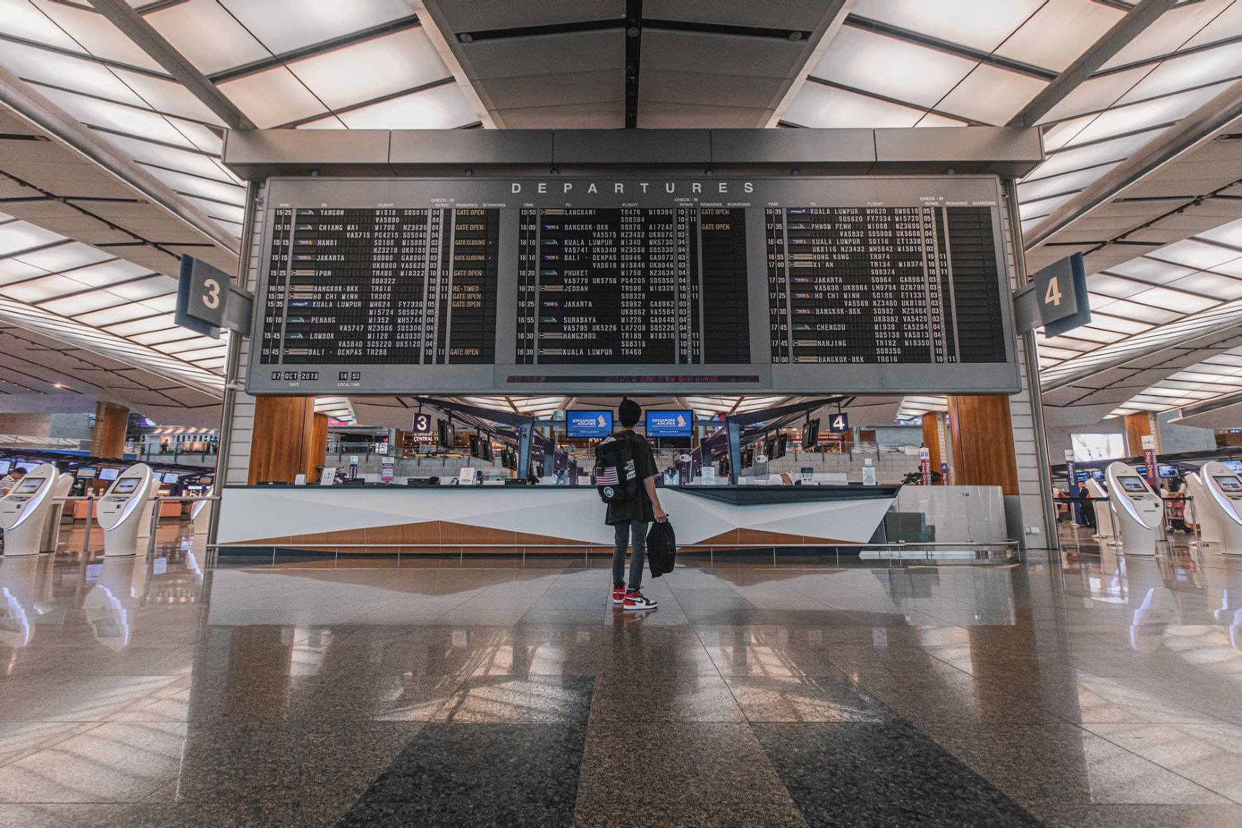 A woman looking at the departures board at the airport 