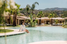 Frau sitzt am Pool des 7 Pines Resort Sardinia