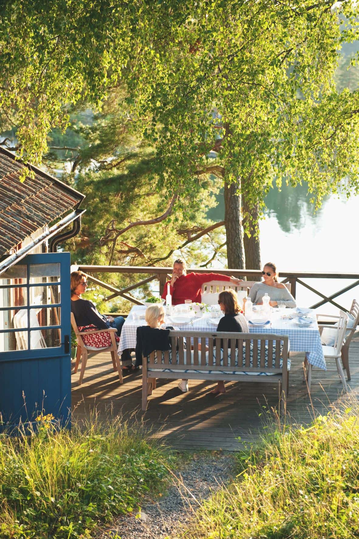 Schweden beim Essen auf einer Terrasse am See 