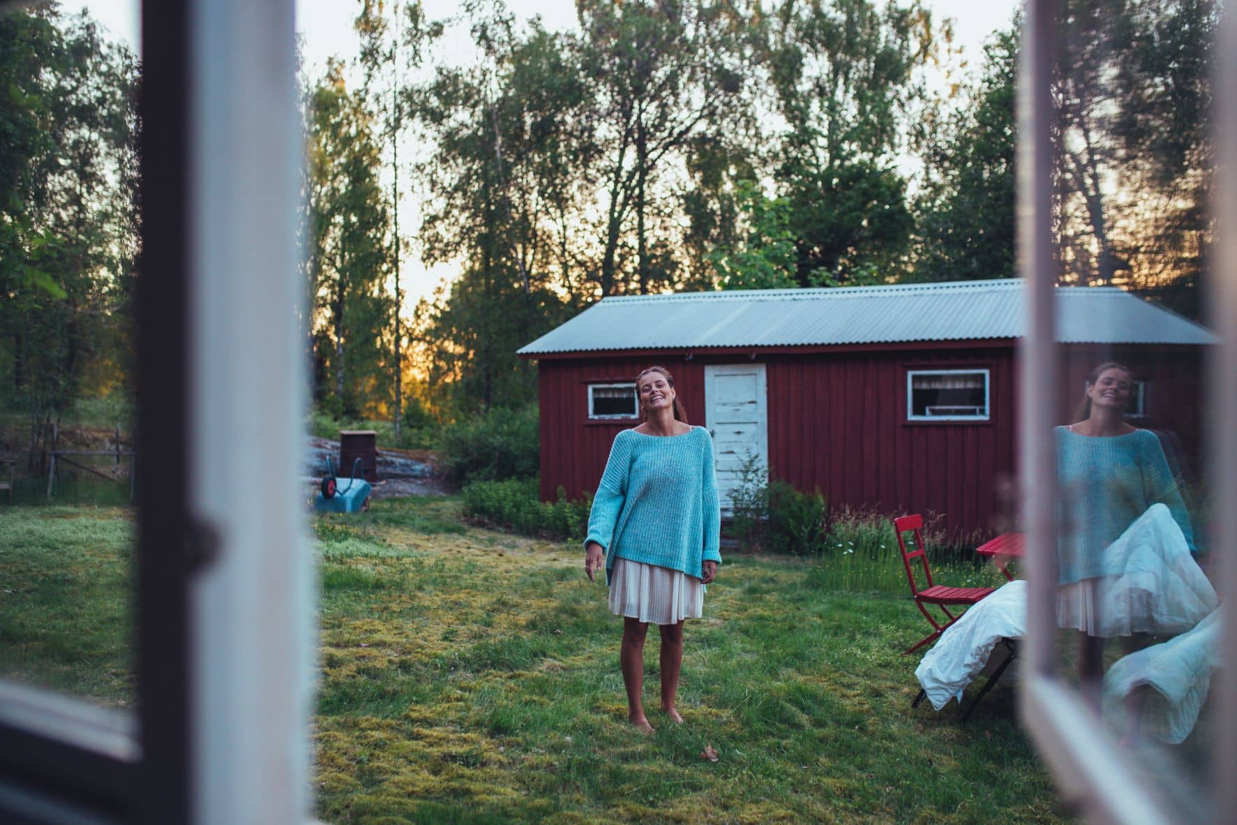 Frau im Garten eines Landhauses in Schweden 