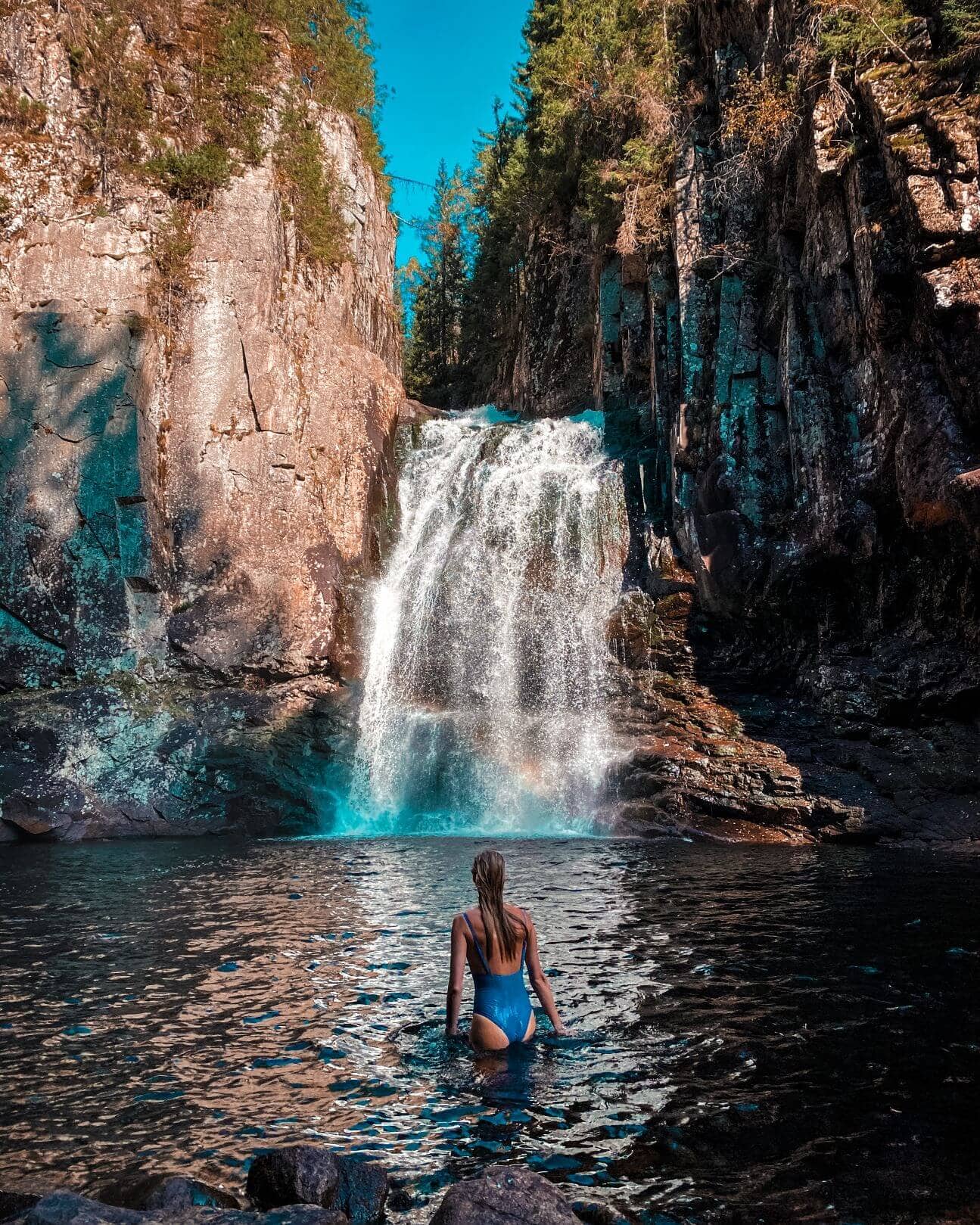 Frau vor dem Wasserfall in Trollfoss 