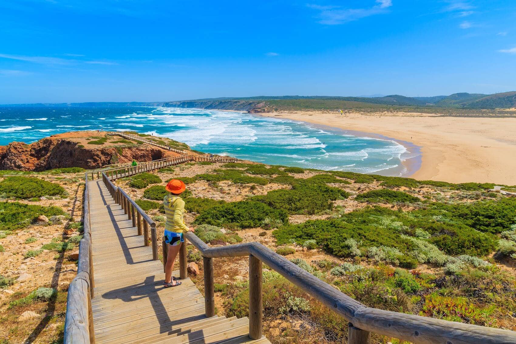 Tourist blickt von Steg auf Strand in Algarve 