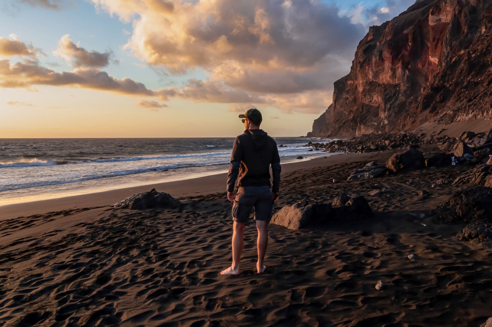 Mann steht am Strand Playa del Ingles auf La Gomera 