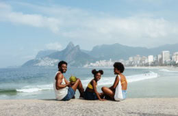 Familie lächelnd am Strand in Rio de Janeiro