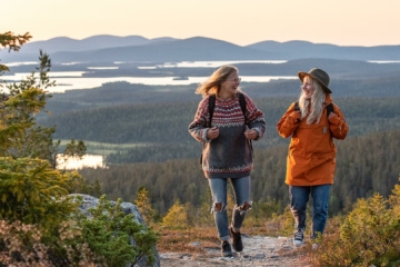 Zwei Wanderinnen unterhalten sich auf einem Trail, im Hintergrund sieht man den Pallas-Ylläs-Nationalpark in Lappland.