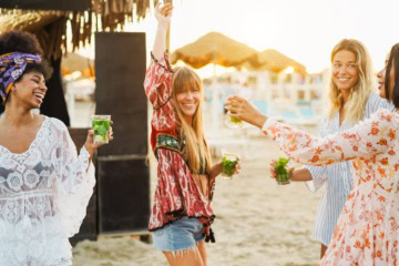 Frauen tanzen in einem Beach Club auf Mykonos