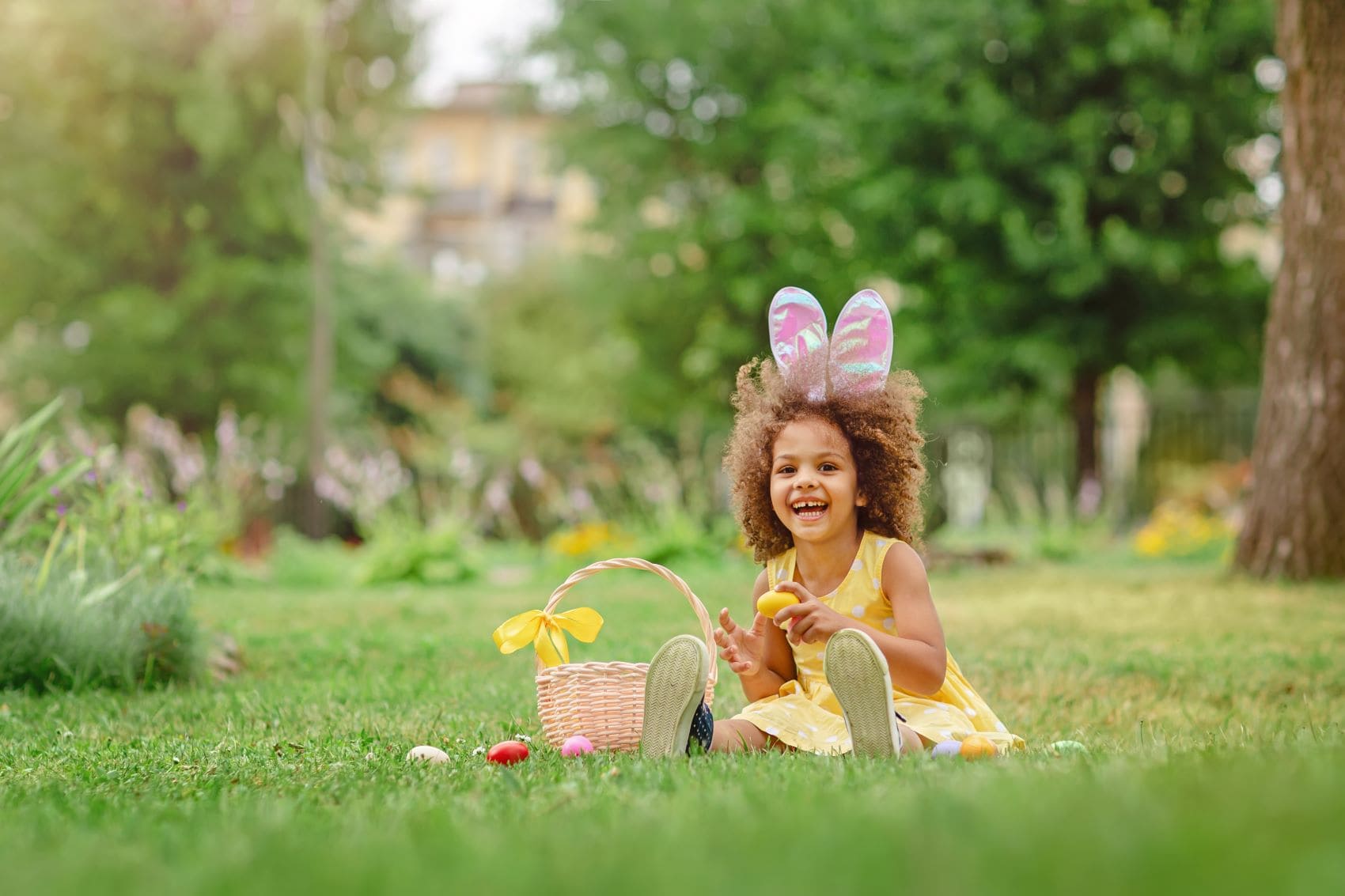 Mädchen sitzt Ostern auf einer Wiese 