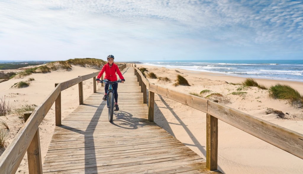 Frau fährt auf Steg am Strand in Portugal