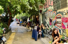 Junge Leute sitzen in Exarcheia, Athen, auf der Terrasse eines Cafes