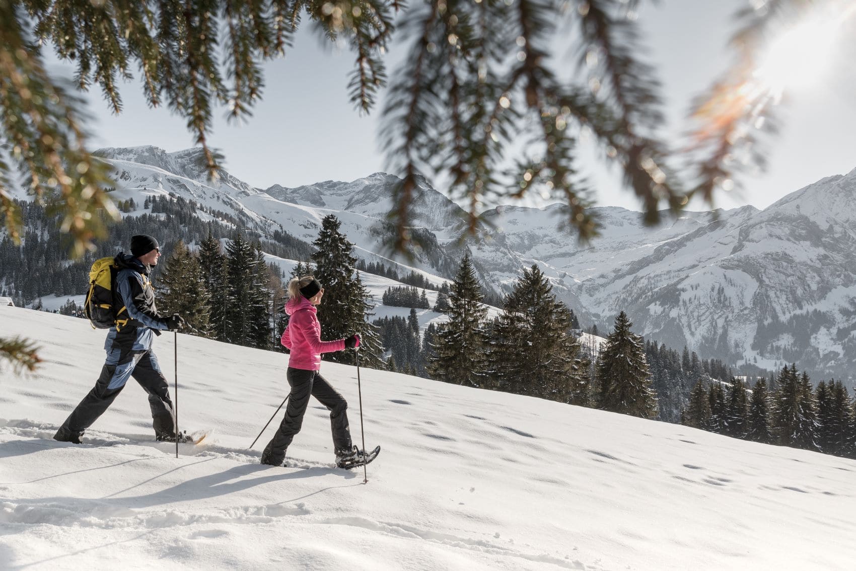 Mann und Frau beim Schneeschuhwandern in Gstaad