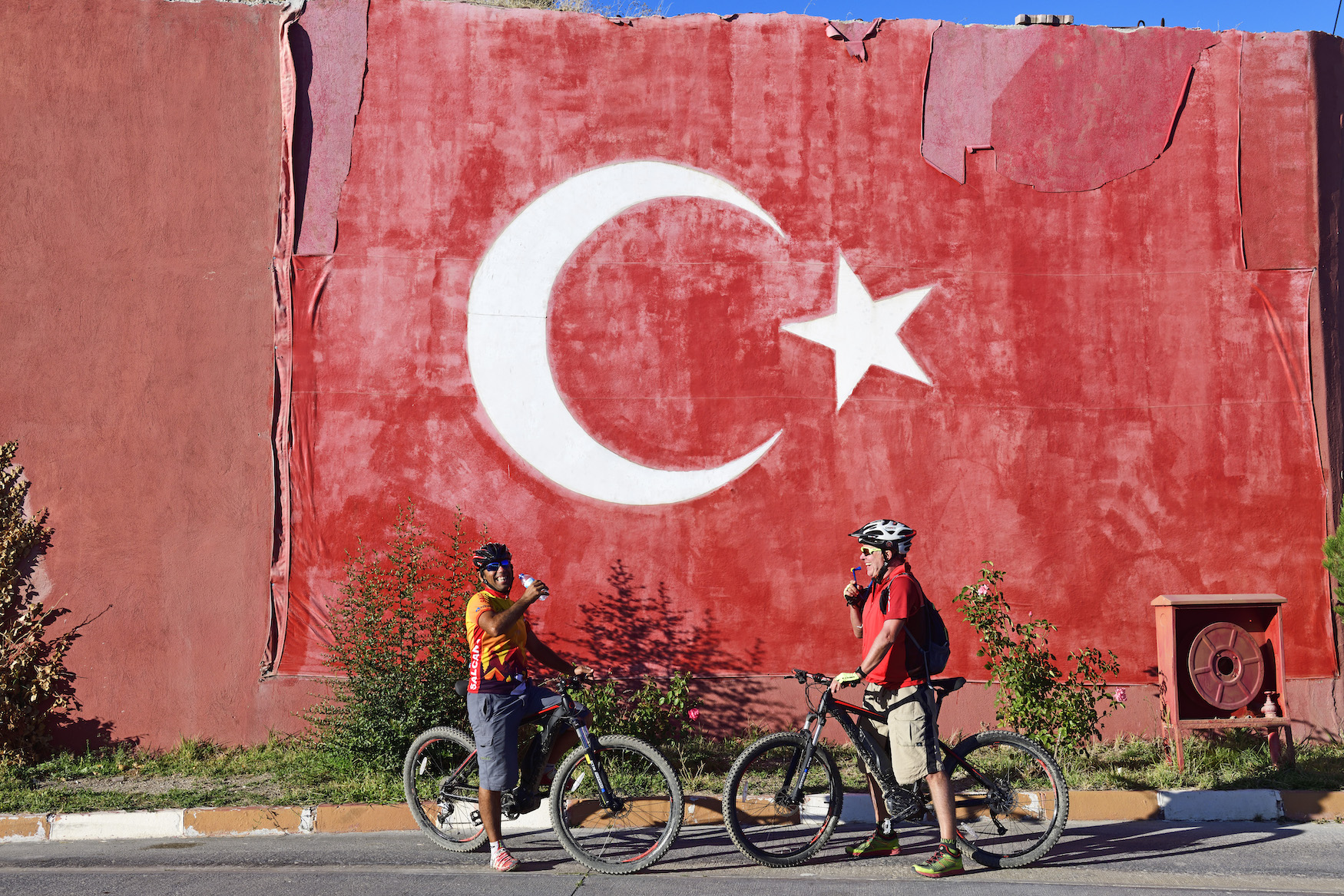 Fahrradfahrer vor der Türkei-Flagge