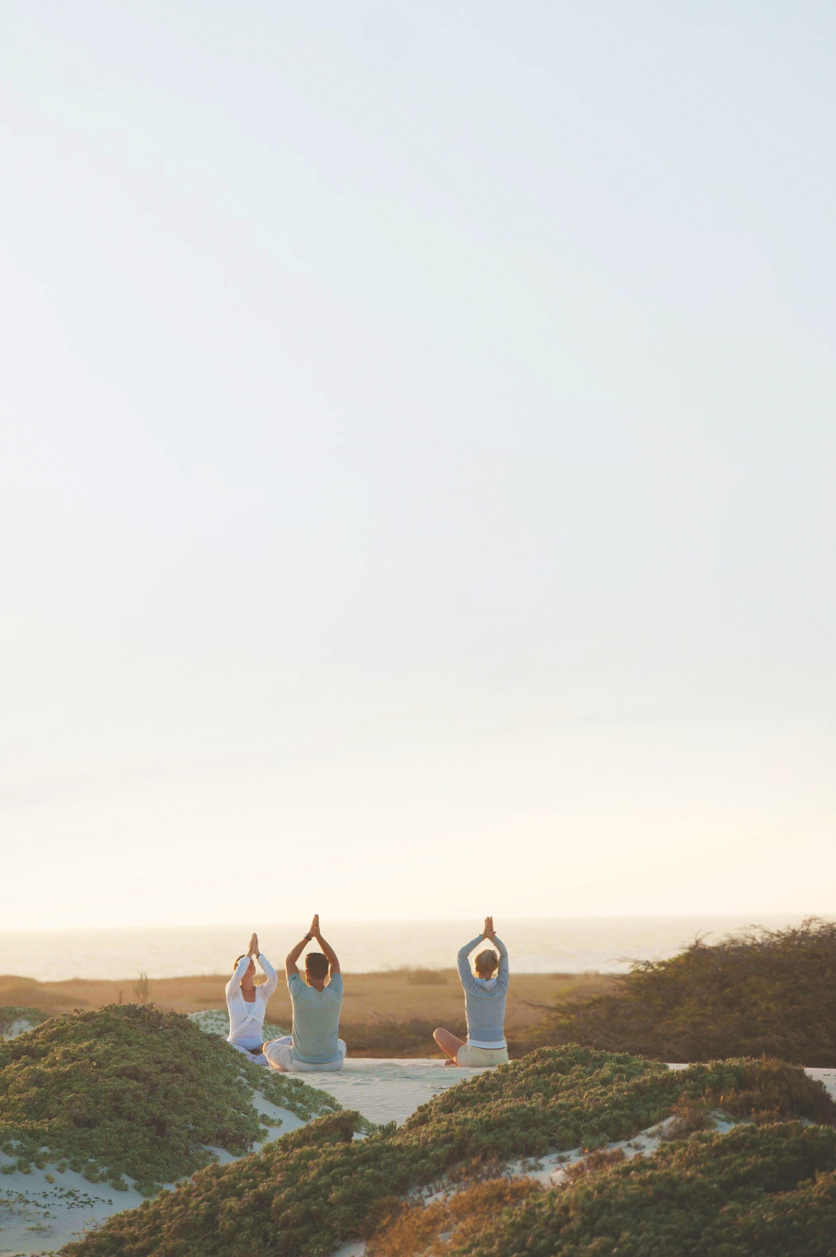 Frau macht Yoga in den Kalifornien-Dünen in der Karibik