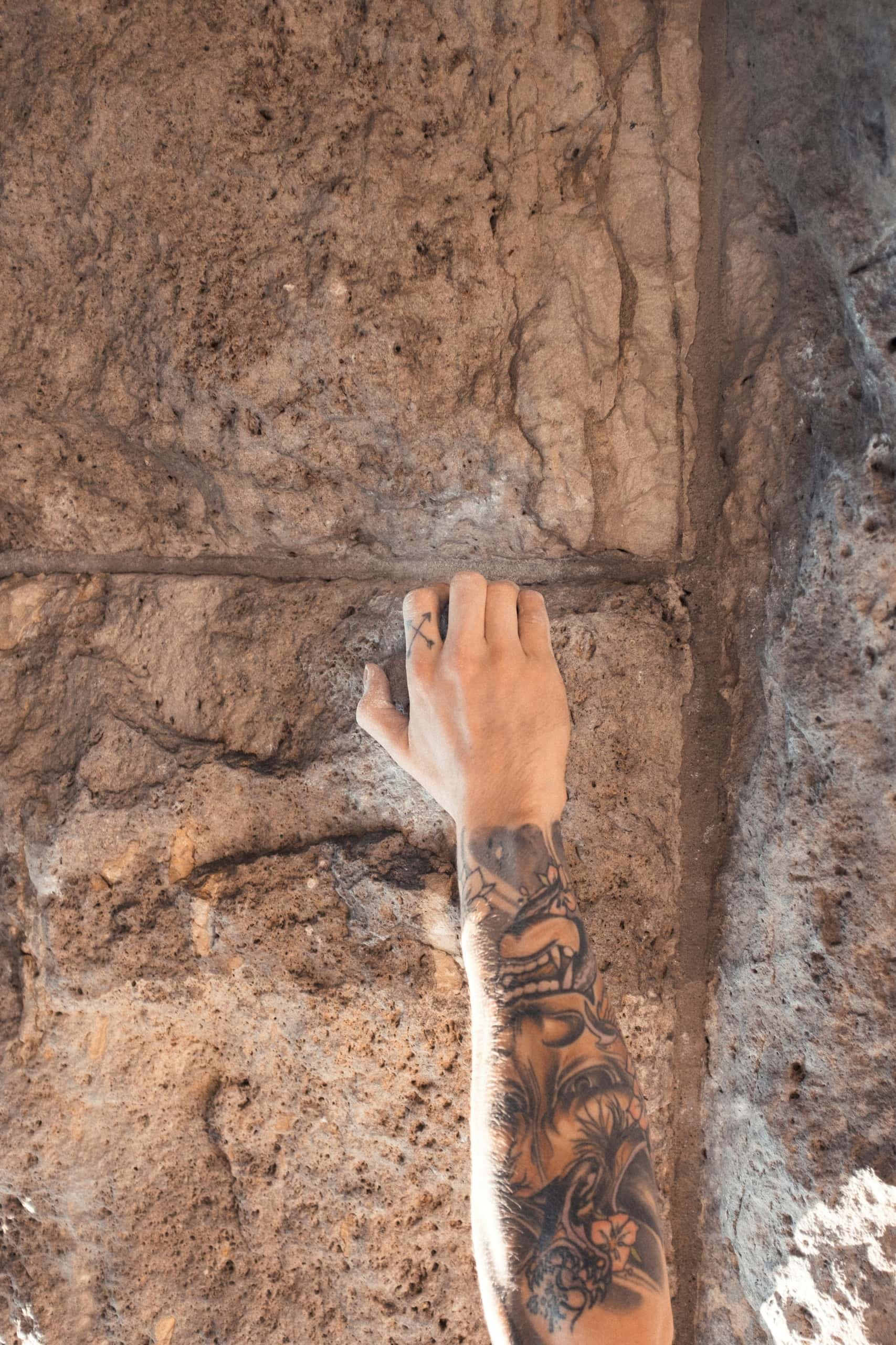 Hand am Fels beim Bouldern