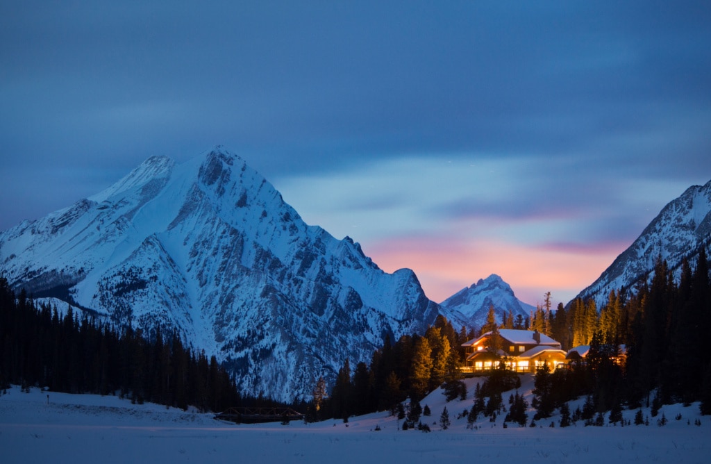 Inmitten schneebedeckter Berge leuchtet Licht aus der Mount Engadine Lodge