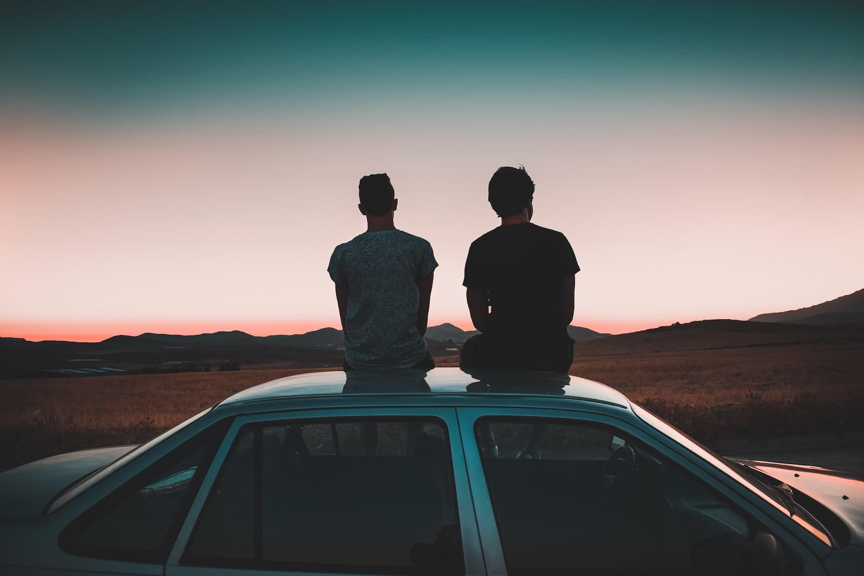 Paar beim Sonnenuntergang auf dem Autodach