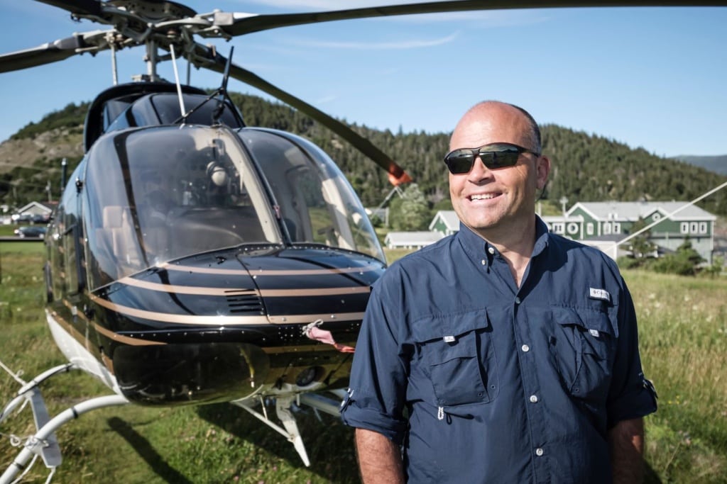 Stan Cook von Rock + Water steht vor einem Helikopter.