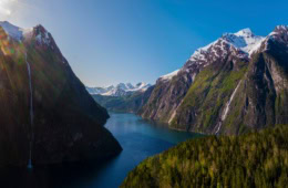 Zwischen zwei Gipfelketten in den Sunnmore-Bergen in Norwegen erstreckt sich im Licht der Sommersonne ein tiefblauer Fjord.