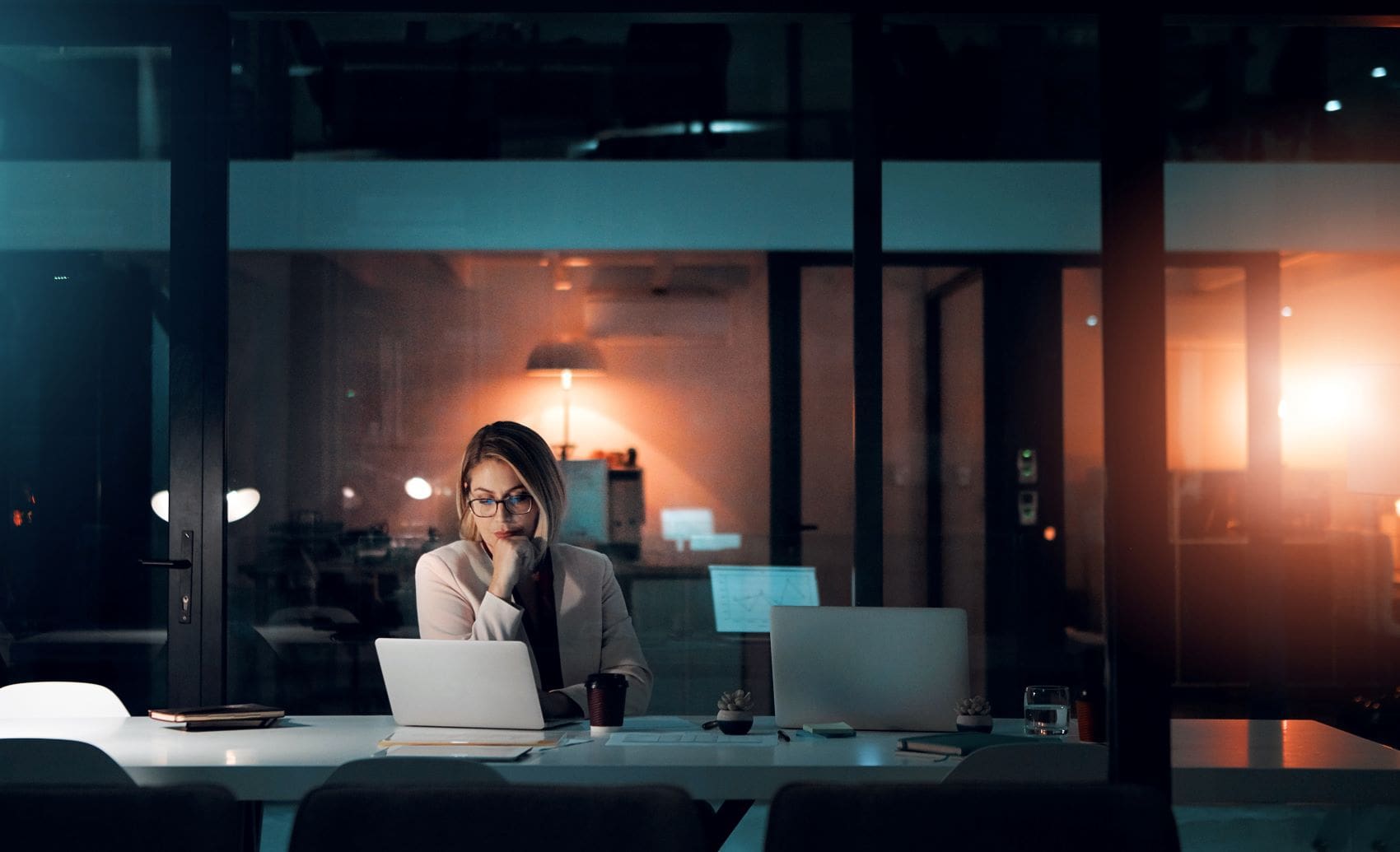 Frau, die im Büro vorm Notebook sitzt und liest