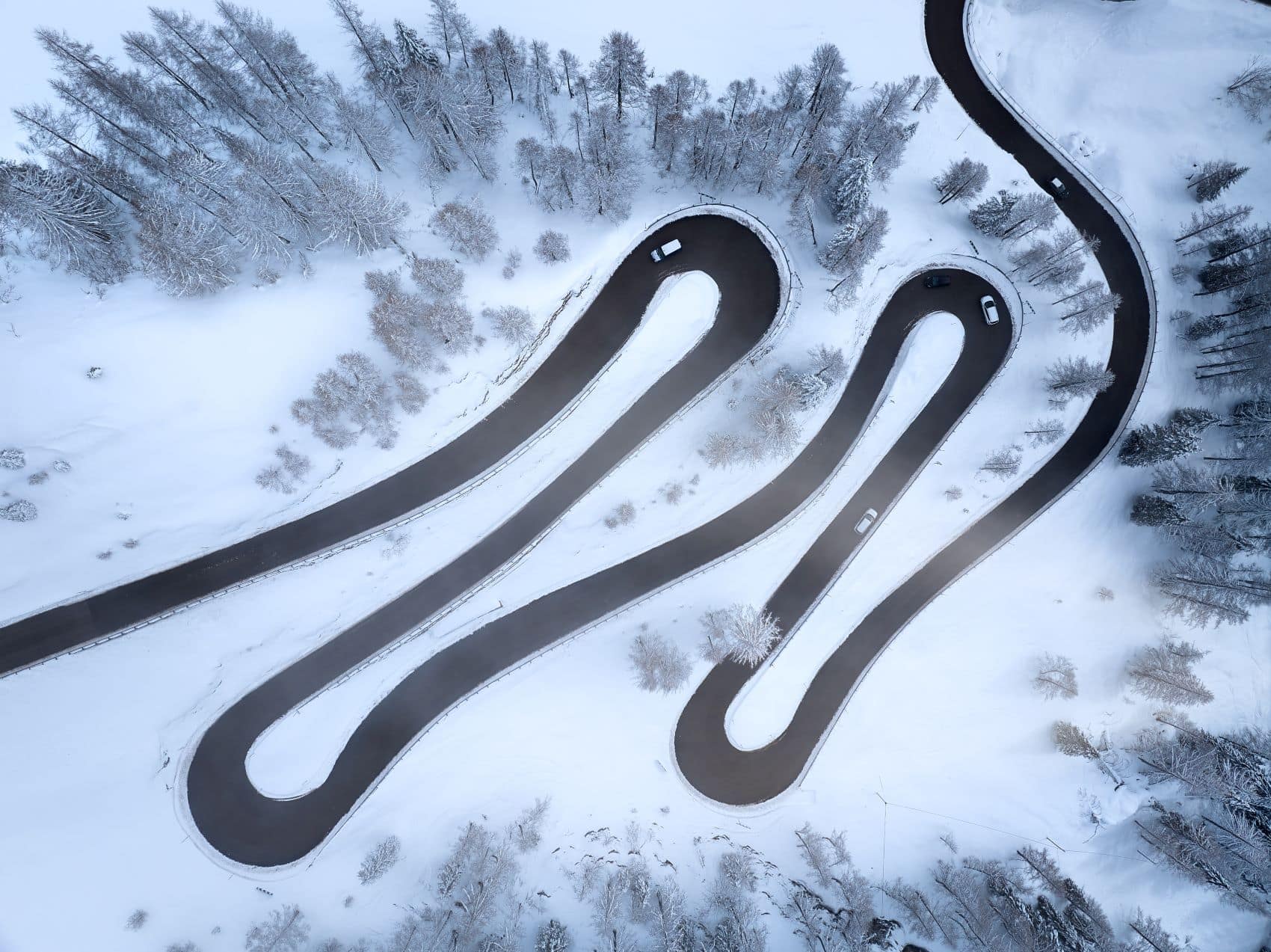 Blick auf in Serpentinen verlaufende Straße im Winter in Dolomiten