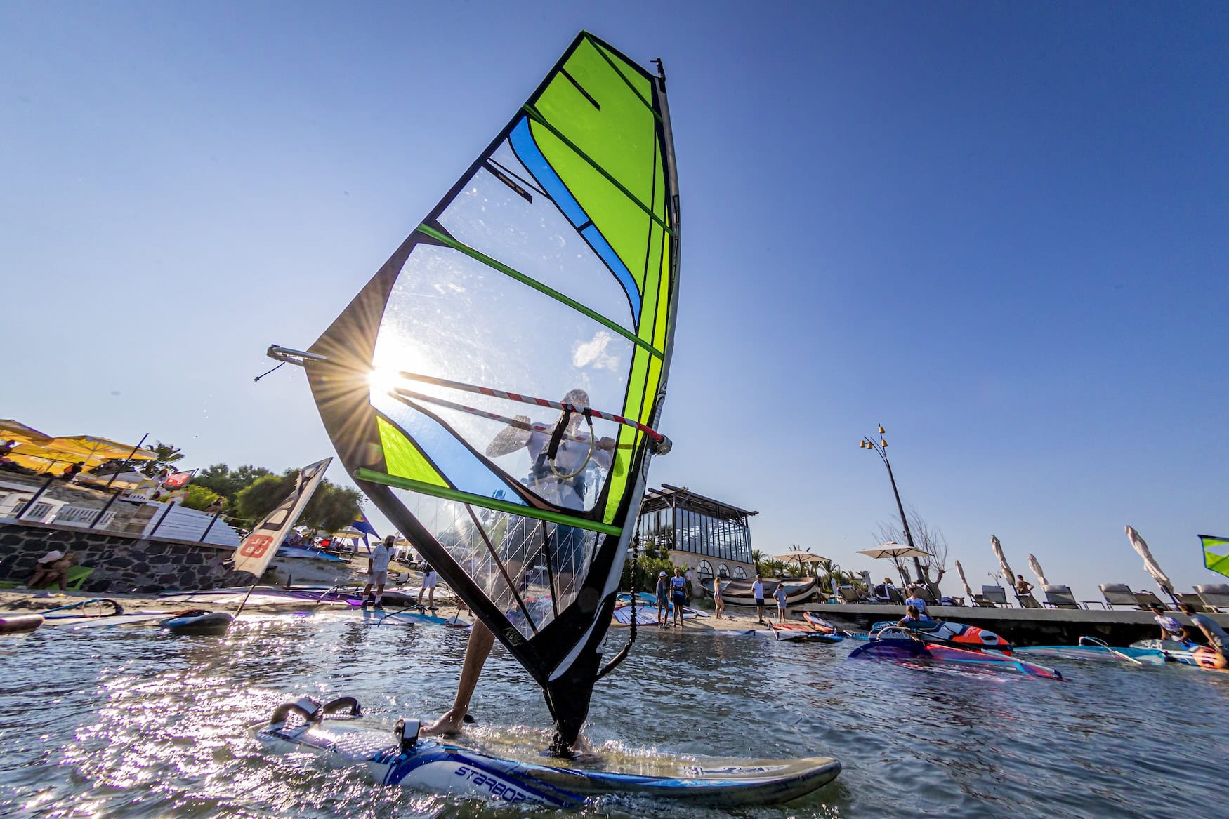 Ein Windsurfer surft übers Meer.