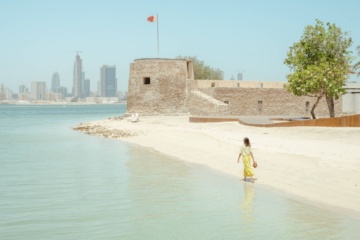 Frau geht in Bahrain am Strand entlang