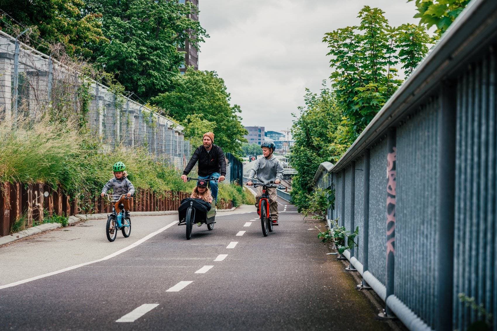 Vater fährt mit seinen drei Kindern auf einer Fahrradstraße in Kopenhagen.