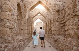 Mann und Frau flanieren durch die Festung Qal at al in Bahrain
