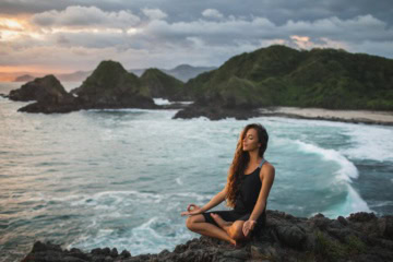 Frau beim Yoga am Strand