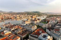 Luftaufnahme von Budapest an einem Sommertag, mit dem gut sichtbaren Parlament im Fokus.
