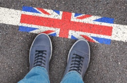 Person steht vor Piktogramm mit Großbritannien-Flagge, auf Straße