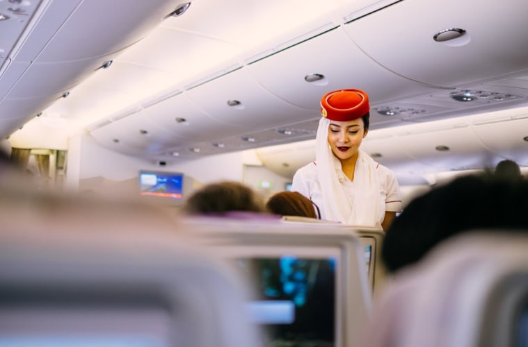 Eine Emirates-Stewardess serviert Essen.