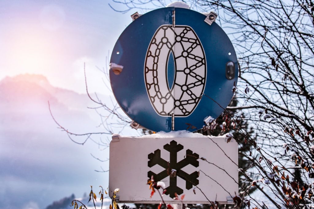 Ein Straßenschild zeigt einen Reifen mit einer Schneekette.