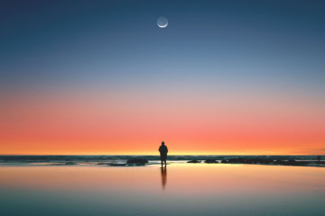 Mann am einsamen Ufer mit Mond