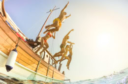 Familie springt von Segelboot ins Wasser