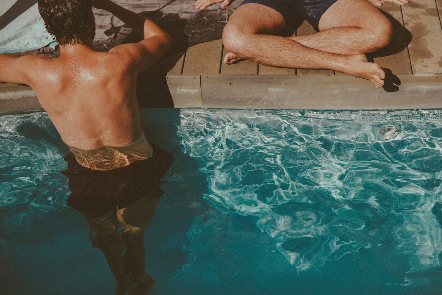 zwei Männer mit gebräunter Haut am Pool