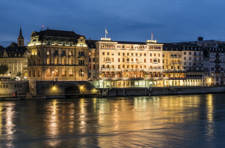 Die Fassade des "Grand Hotel Les Trois Rois" bei Nacht in Basel, Schweiz