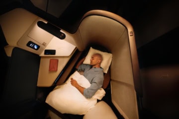 Mann schläft in der Business Class von Cathay Pacific