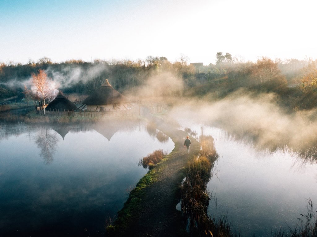 Mann läuft über einen Steg im Nebel im The Irish Heritage Park in Irland
