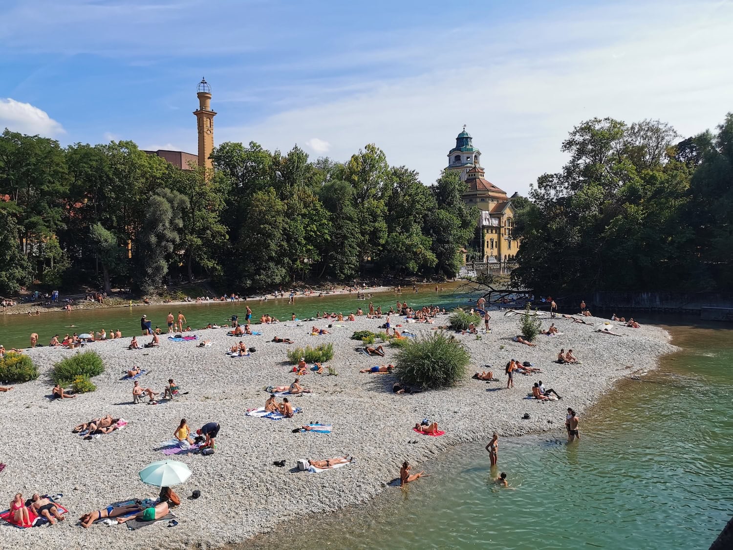 Menschen baden in der Isar inmitten von München