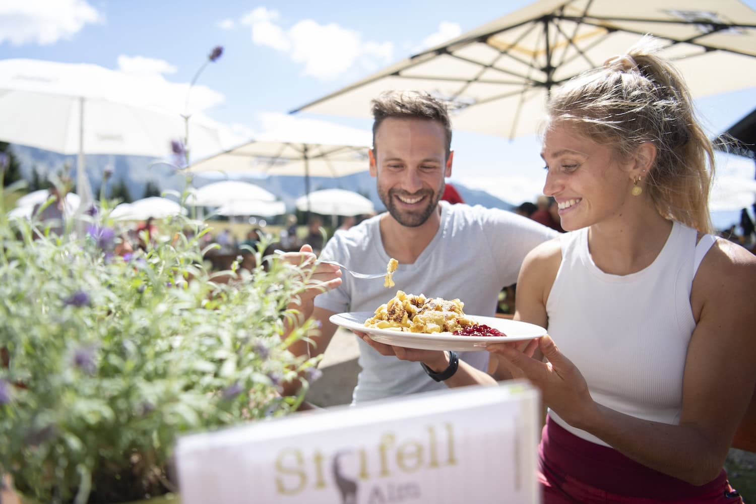 zwei Menschen auf einer Almhütte, die essen