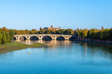 Panoramablick auf die Pont Neuf, die in Toulouse in strahlendem Sonnenscheind über die Garonne führt