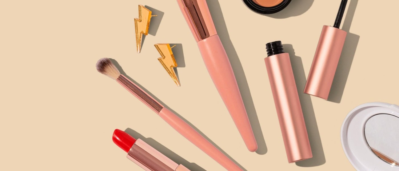 Beauty-Produkte für den Urlaub liegen auf einem hellen Untergrund