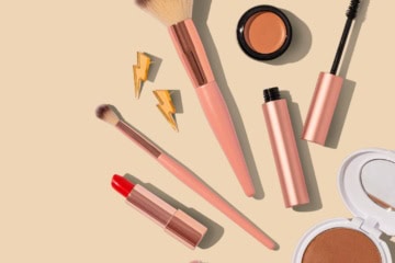 Beauty-Produkte für den Urlaub liegen auf einem hellen Untergrund