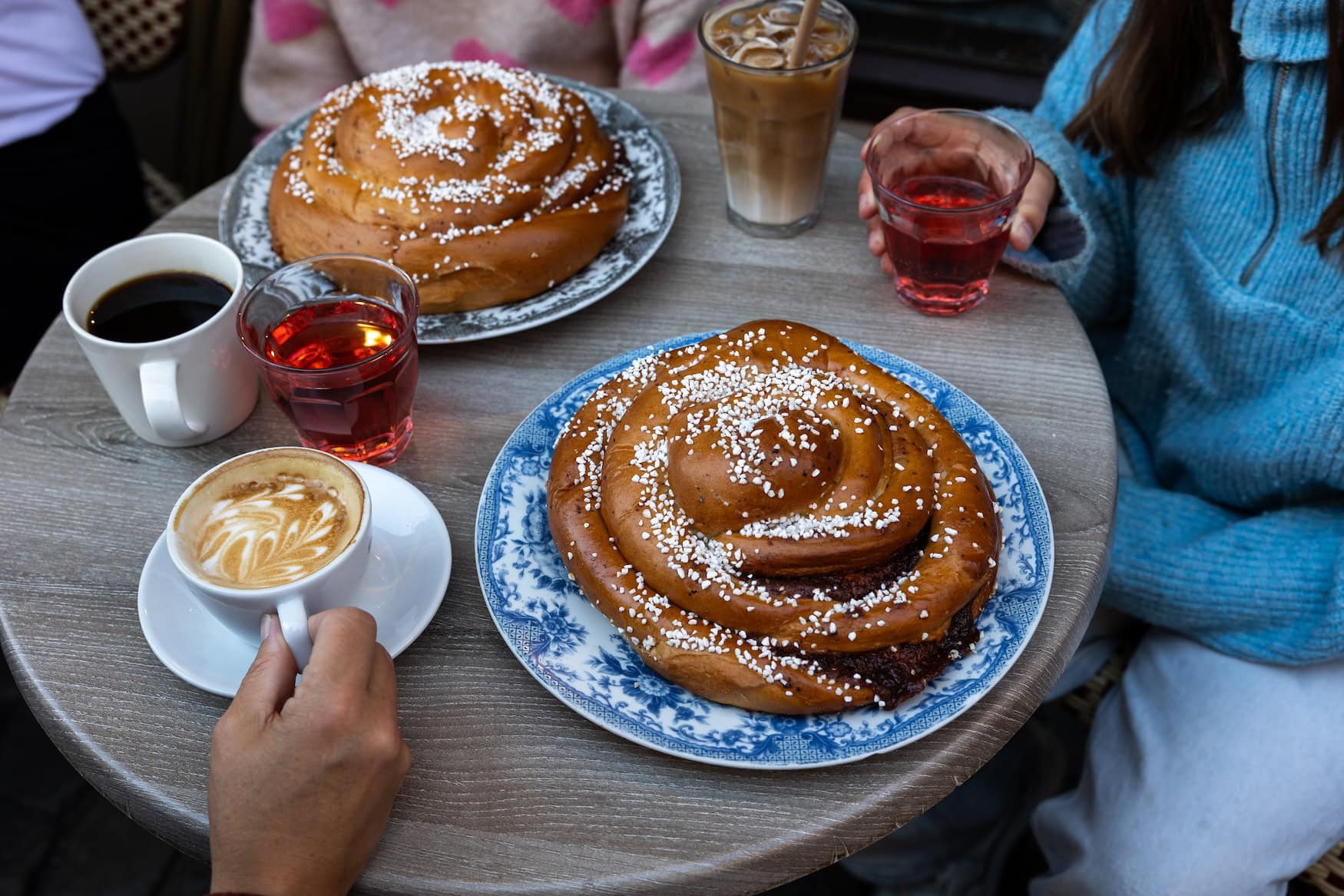 Zimtschnecken und heiße Getränke auf einem Tisch in einem Café in Göteborg.